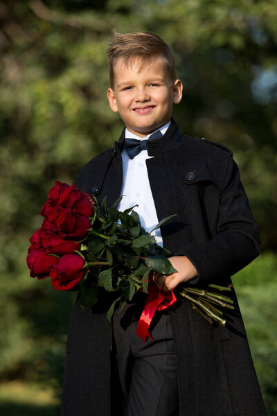 Portrait of a boy, a schoolboy with a bouquet of flowers in the 