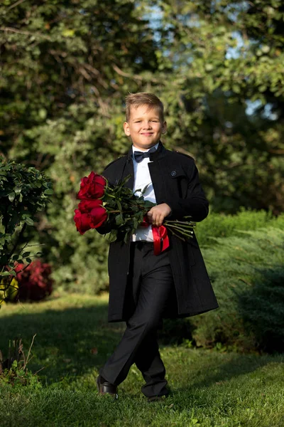 Портрет мальчика, школьника с букетом цветов в — стоковое фото