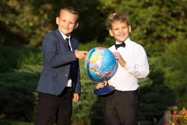 Dikey iki erkek arkadaş, okul çocukları ile küreler içinde