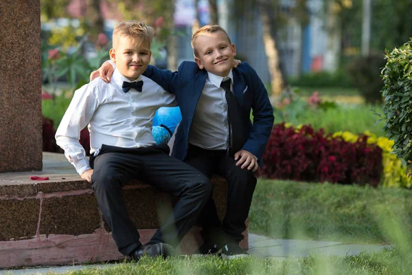 Dikey iki erkek arkadaş, okul çocukları ile küreler içinde