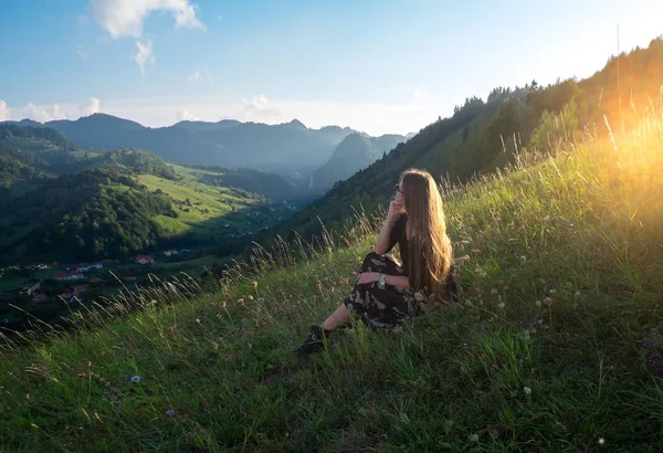 Güzel kız, akşam güneşi ile dağlarda modelinde bir