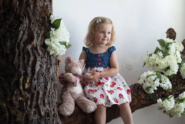 Retrato de uma menina sentada numa árvore. Retrato, infância — Fotografia de Stock