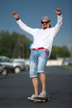 Bir adam bir kaykay dışarıda güneşli bir günde biniyor. Spor, hareket