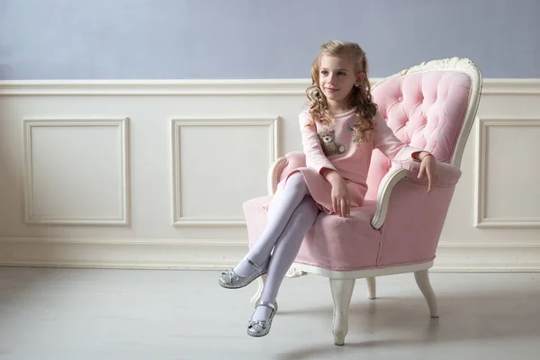 Yumuşak renkler bir odada bir sandalyede oturan kız. Portre, c