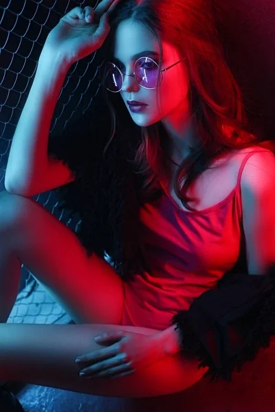 Chica, modelo en un abrigo de piel negro, de moda y gafas de sol en un — Foto de Stock