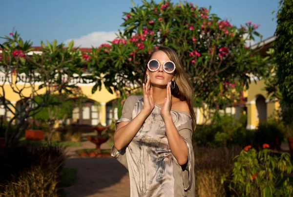 Menina bonita e elegante, modelo passeia em um jardim tropical perto — Fotografia de Stock