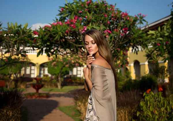 Menina bonita e elegante, modelo passeia em um jardim tropical perto — Fotografia de Stock