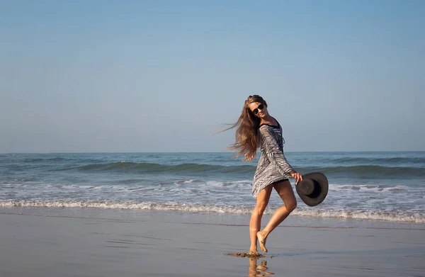 Όμορφο, κομψό κορίτσι, μοντέλο βόλτες κατά μήκος της ακτής. ΤΟΠΜΑΚ — Φωτογραφία Αρχείου