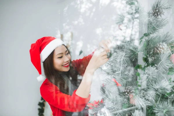 Feliz joven asiática mujer apertura bolsa de compras cerca de árbol de Navidad —  Fotos de Stock