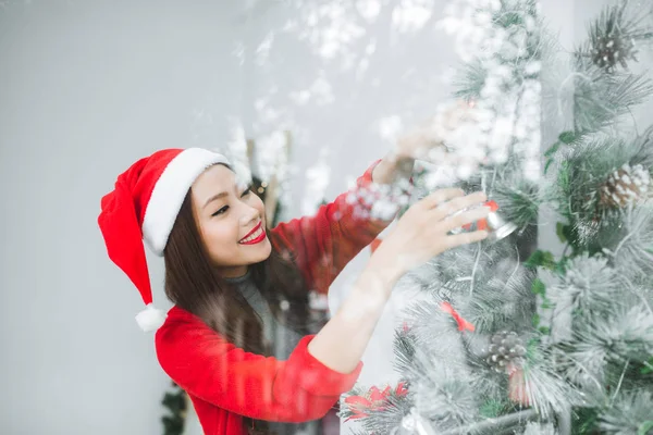 Feliz jovem asiático mulher abertura compras saco perto de natal árvore — Fotografia de Stock