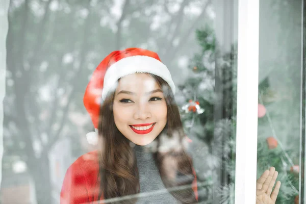 Feliz jovem asiático mulher abertura compras saco perto de natal árvore — Fotografia de Stock