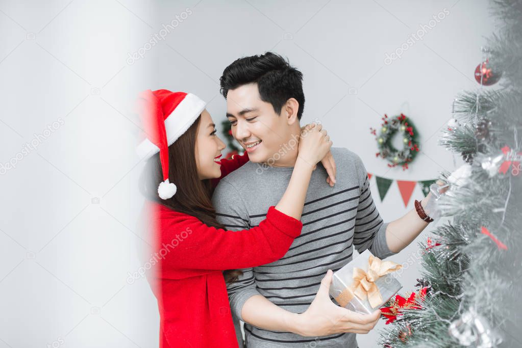 Christmas Asian Couple.Happy Smiling Family at home celebrating.