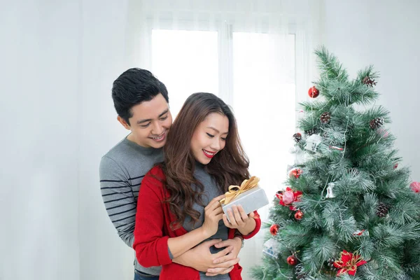 Pareja asiática de Navidad. Un hombre guapo dando a su novia / esposa un regalo en casa celebrando el Año Nuevo Personas —  Fotos de Stock