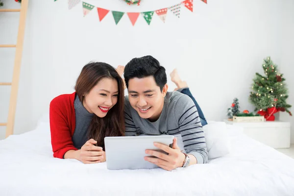 No Natal. Casal asiático usando tablet digital em casa comemorando — Fotografia de Stock