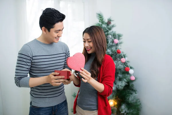 Casal asiático de Natal. Um homem bonito dando sua namorada / esposa — Fotografia de Stock