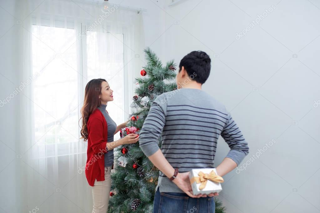 Christmas Asian Couple. A handsome man giving her girlfriend/wif