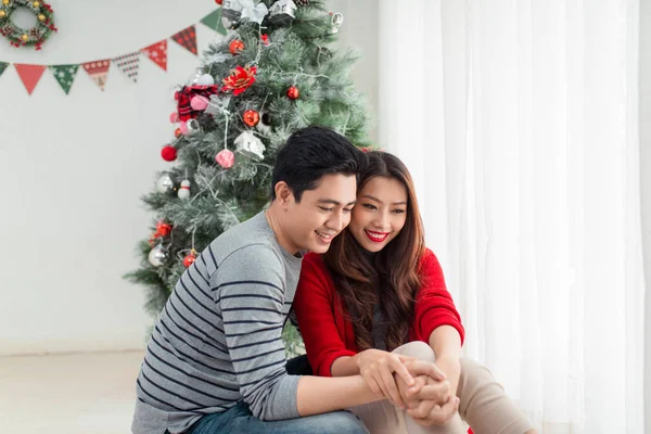 Pareja sentada cerca del árbol de Navidad —  Fotos de Stock