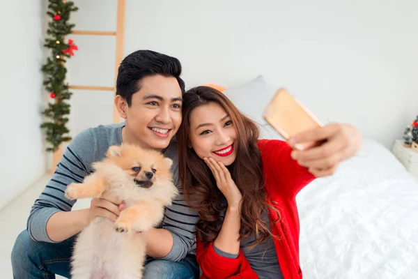 Casal com cão tomando selfie — Fotografia de Stock