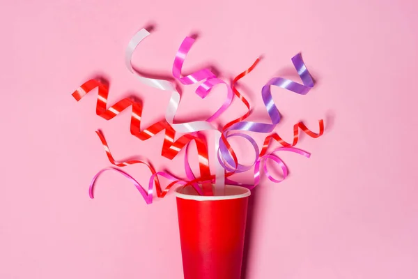 Paper cup with colorful party streamers — Stock Photo, Image