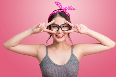 Pembe üzerinde durup gözlüklü Asyalı kız moda portre 