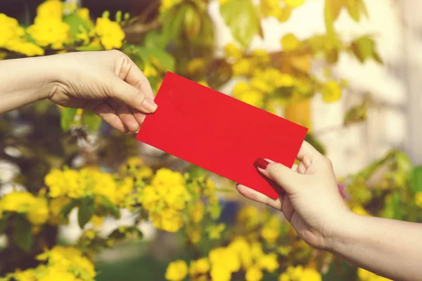 Hand give money in red envelopes - ang pow or red packet to some — Stock Photo, Image