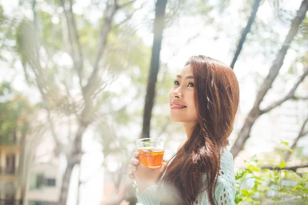 Retrato de una joven asiática bebiendo su té de la mañana. Cayó r — Foto de Stock