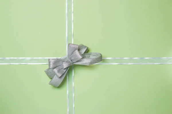 Ruban blanc avec noeud sur fond vert . — Photo