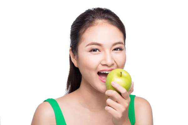 Ελκυστική χαμογελαστός νεαρός ασιατική γυναίκα τρώει πράσινο μήλο απομονωθεί σε λευκό φόντο. — Φωτογραφία Αρχείου