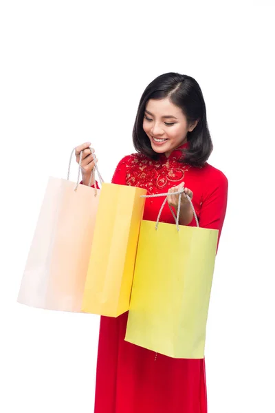 Retrato de una hermosa mujer asiática en traje de festival tradicional Ao Dai sosteniendo bolsas de compras . — Foto de Stock