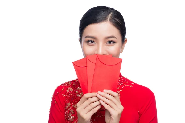 Porträt einer schönen asiatischen Frau in traditioneller Festtagstracht ao dai mit roter Tasche - Glücksgeld. Es ist Feiertag. Mondneujahr. — Stockfoto