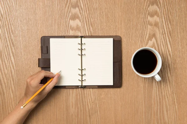 Concepto de planificación empresarial y concepto de resoluciones de año nuevo. Vista superior de la escritura a mano en un cuaderno en blanco con café caliente . — Foto de Stock