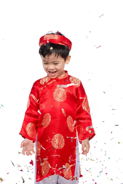 Feliz niño vietnamita en rojo Ao Dai celebrando el Año Nuevo con confeti. Asiático niño celebrando año nuevo —  Fotos de Stock