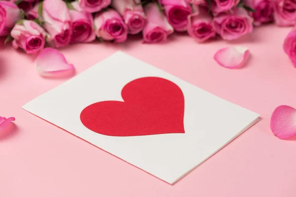 Carte de voeux Saint-Valentin avec des fleurs roses sur fond rose. Vue supérieure avec espace de copie — Photo