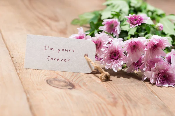 발렌타인의 하루입니다. 나무 테이블에 종이 태그와 핑크 꽃. — 스톡 사진