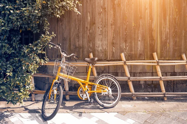 Bicicleta amarilla en pared de madera vintage — Foto de Stock