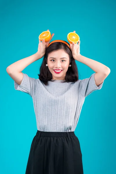 Ασιατικό κορίτσι κρατώντας κομμάτια πορτοκαλιού — Φωτογραφία Αρχείου