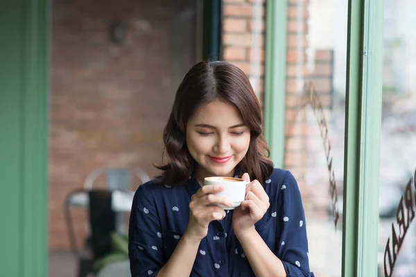 woman holding mug drinking coffee