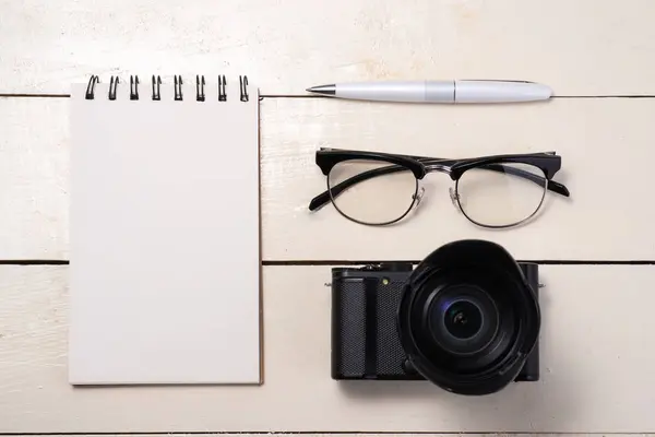 Kamera, Stift, Brille und Notizbuch — Stockfoto