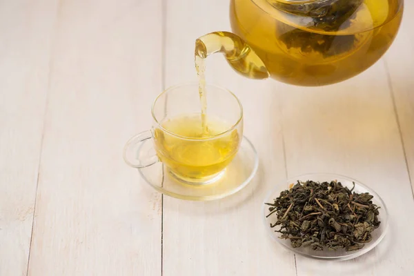 Taza de té caliente y hojas de té — Foto de Stock