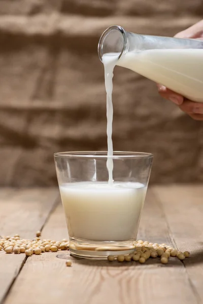 Hand gießt Milch ins Glas — Stockfoto