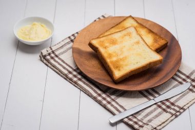 Ahşap masa üzerinde tereyağlı tost ekmek dilimi Close-Up