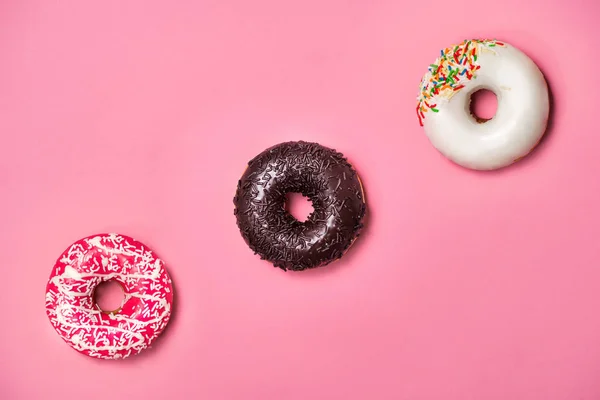 Donuts avec glaçage sur fond rose pastel. Doux beignets. — Photo