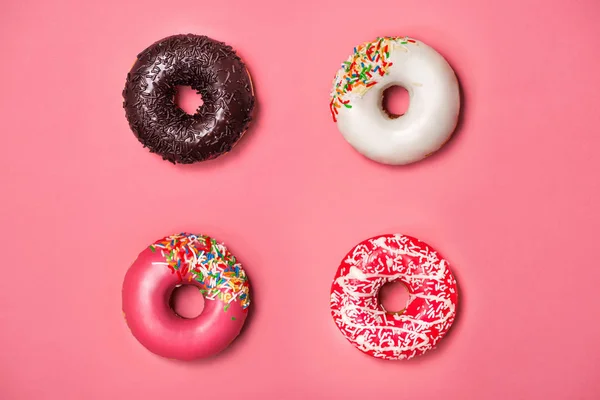 Donuts con glaseado sobre fondo rosa pastel. Rosquillas dulces. — Foto de Stock