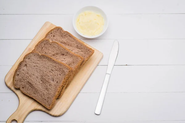 木のテーブルにバターとトーストのスライスのクローズ アップ — ストック写真