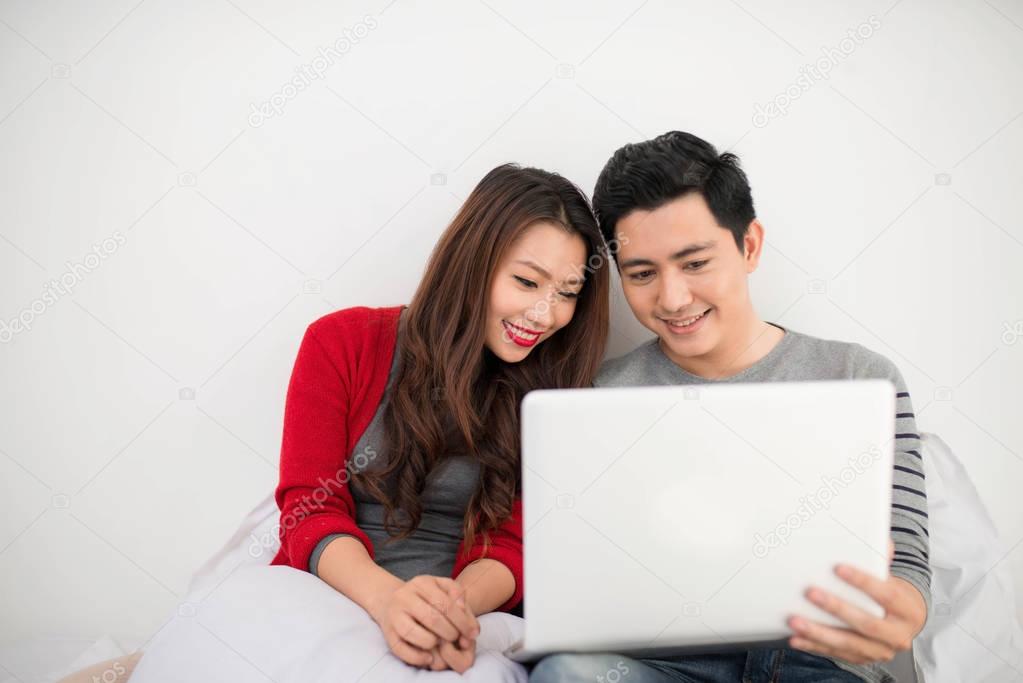 Asian couple lovers using laptop at home