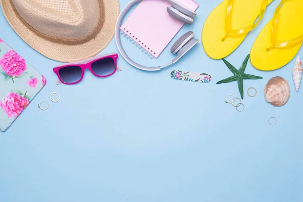 Conceito de verão. Bolsa rosa com acessórios em fundo azul claro — Fotografia de Stock