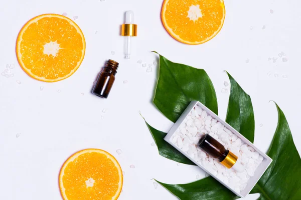 Branding mock-up. Óleo essencial natural, recipientes de garrafa de cosméticos com fatias de laranja . — Fotografia de Stock