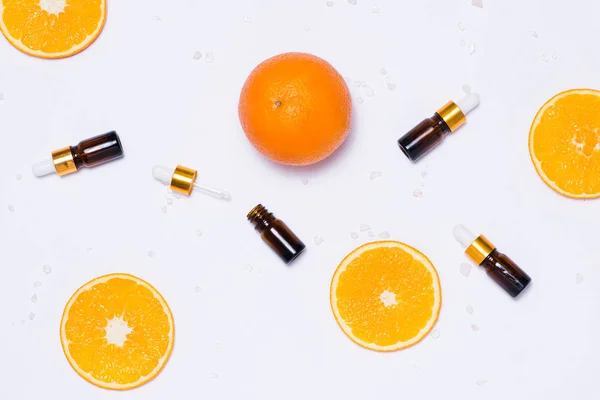 Una maqueta de marca. Aceite esencial natural, frascos cosméticos con rodajas de naranja . —  Fotos de Stock