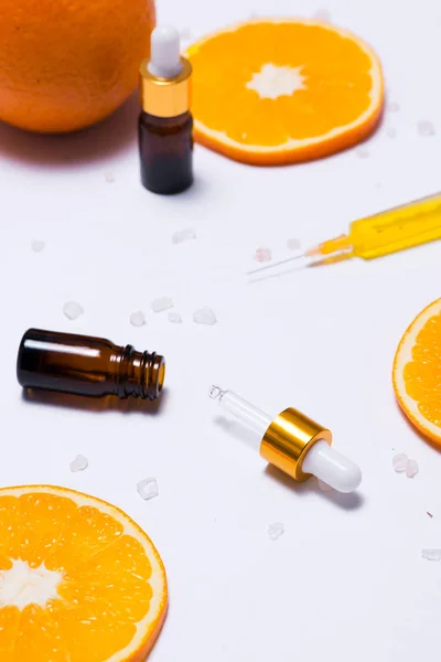 Branding mock-up. Óleo essencial natural, recipientes de garrafa de cosméticos com fatias de laranja . — Fotografia de Stock