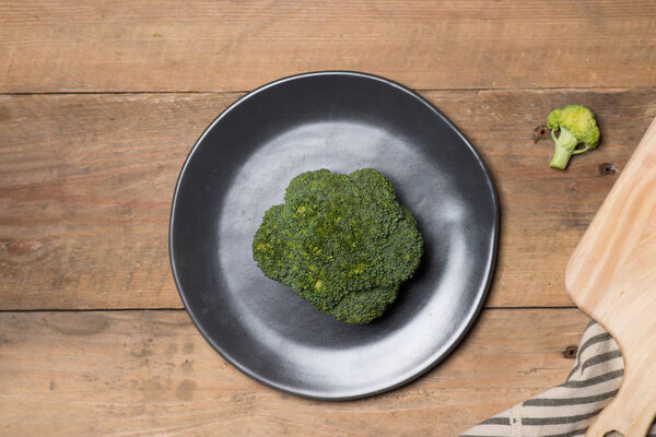 Fresh broccoli in dish on a wooden background